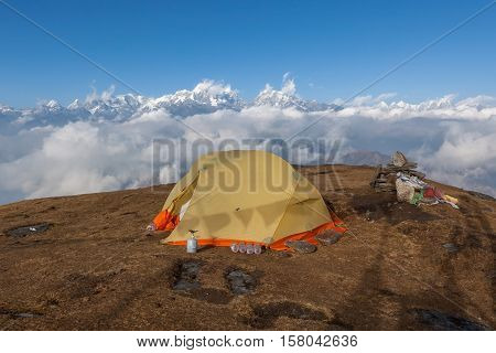 Camping Tent On The Top Of The Pikey Peak Mountain. Cloudy Weather And Snowy Peaks On The Background