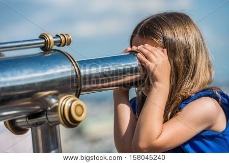 Paris, France- June 30, 2013: Little Girl Looking Through Sightseeing Binoculars Monuments Of Paris