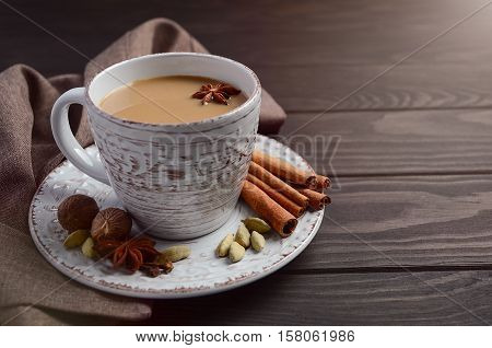 Indian masala chai tea. Spiced tea with milk on the rustic wooden table. Selective focus, horizontal with copy space.