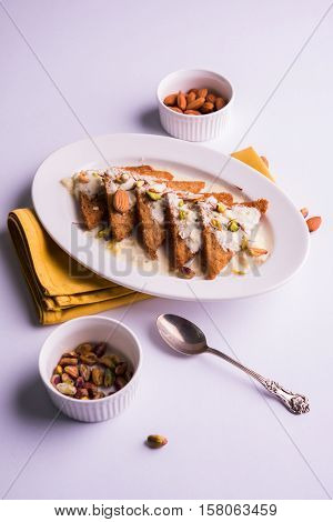 Shahi Tukda prepared - deep fried bread in ghee, garnish with sweetened cream and dry fruits. Indian sweet dish