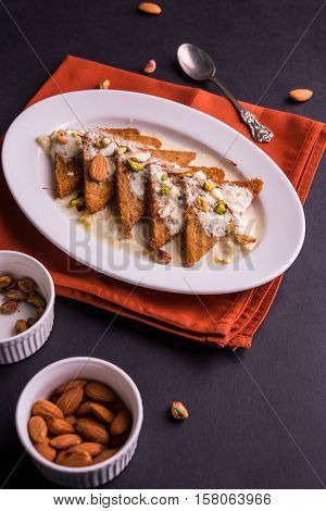 Shahi Tukda prepared - deep fried bread in ghee, garnish with sweetened cream and dry fruits.