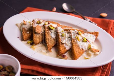 Shahi Tukda prepared - deep fried bread in ghee, garnish with sweetened cream and dry fruits.