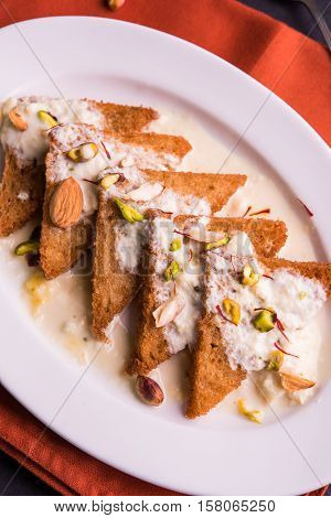 Shahi Tukda prepared - deep fried bread in ghee, garnish with sweetened cream and dry fruits.