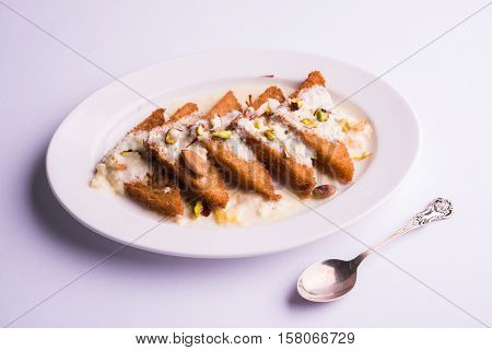 Shahi Tukda prepared - deep fried bread in ghee, garnish with sweetened cream and dry fruits.