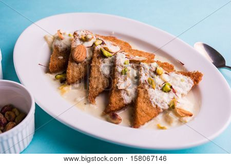 Shahi Tukda prepared - deep fried bread in ghee, garnish with sweetened cream and dry fruits.