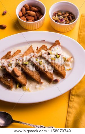 Shahi Tukda prepared - deep fried bread in ghee, garnish with sweetened cream and dry fruits.