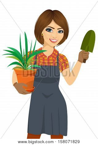 gardening beautiful woman holding green Chlorophytum plant in pot and trowel