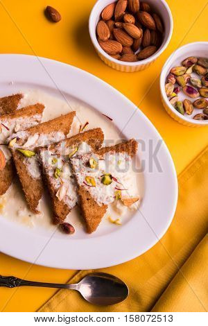Shahi Tukda prepared - deep fried bread in ghee, garnish with sweetened cream and dry fruits.