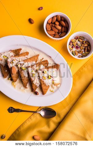 Shahi Tukda prepared - deep fried bread in ghee, garnish with sweetened cream and dry fruits.
