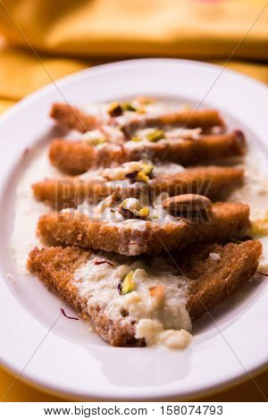Shahi Tukda prepared - deep fried bread in ghee, garnish with sweetened cream and dry fruits.