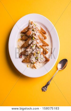 Shahi Tukda prepared - deep fried bread in ghee, garnish with sweetened cream and dry fruits.