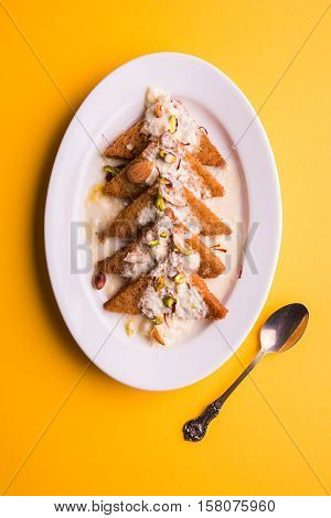 Shahi tukda prepared - deep fried bread in ghee, garnish with sweetened cream and dry fruits.
