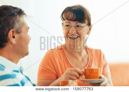 Senior couple enjoying living room early in the morning.