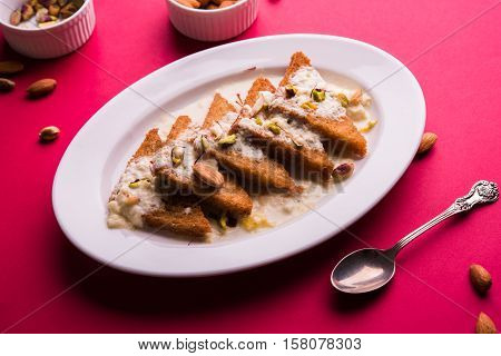 Shahi tukda prepared - deep fried bread in ghee, garnish with sweetened cream and dry fruits.