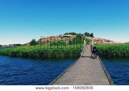 Wooden pier to the island. Bicycle on the wooden bridge. Karlskrona, Sweden