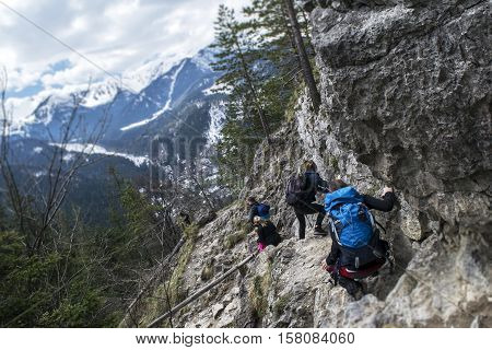 Tourists coming down from the steep slope in the mountains. Tatry, Poland