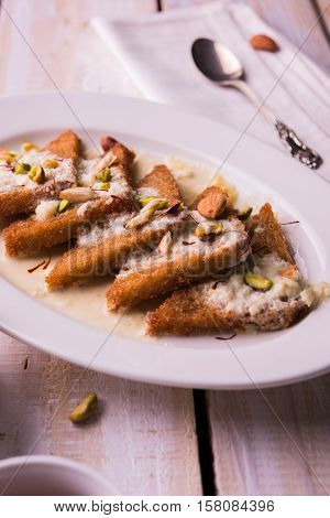 Shahi tukda prepared - deep fried bread in ghee, garnish with sweetened cream and dry fruits.