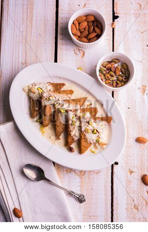 Shahi tukda prepared - deep fried bread in ghee, garnish with sweetened cream and dry fruits.