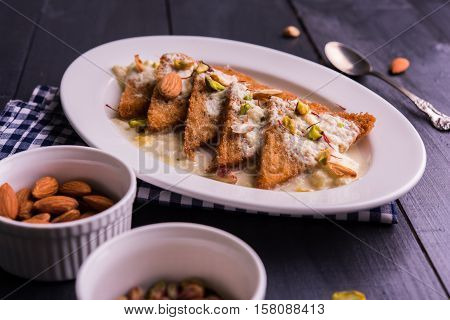 Shahi tukda prepared - deep fried bread in ghee, garnish with sweetened cream and dry fruits.