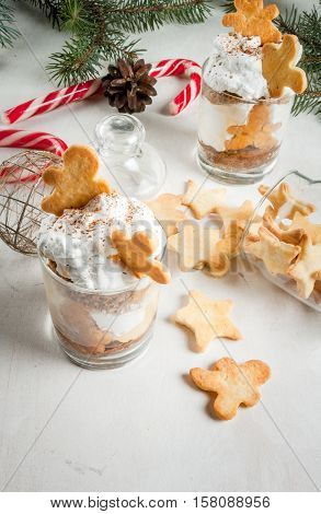Christmas dessert funny food for children or party. Ginger Trifle with gingerbread in form of men diving in the drifts of whipped cream. Copy space