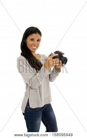 portrait of young beautiful and exotic hispanic photographer woman smiling happy and relaxed isolated on white background looking photographic reflex camera excited and cheerful