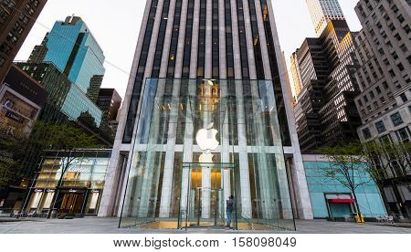 New York New York - USA April 28th 2016. the Apple Store in Manhattan with empty streets and only one person an apple employee looking up at the Apple logo