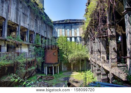 Abandoned, destroyed by war and overgrown machinery of Tkvarcheli power plant, Abkhazia, Georgia