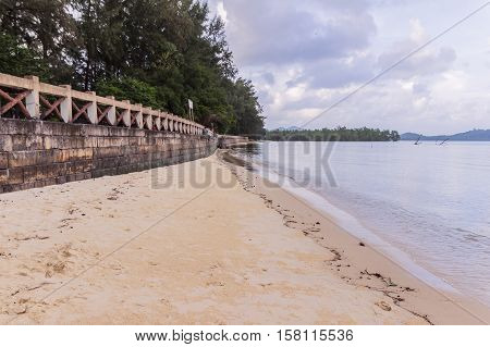 Beachside concrete retaining wall when low tide in the evening Phuket Thailand