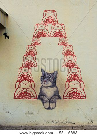 Georgetown, Penang, Malaysia - February 18, 2015: The mural of cat for luck, street art on wall by local artist in George Town, Penang, Malaysia.