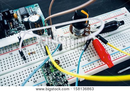 Close-up of breadboard with electronic components. New program development in laboratory with special equipment. Electronics construction concept