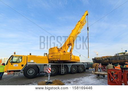 MOSCOW, RUSSIA - NOVEMBER 11, 2016: State Unitary Enterprise Mosvodostok performs recovery vessels on coastal winter parking. Vehicle crane in the operative position, mounted on metal supports.