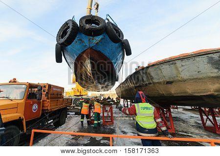 MOSCOW, RUSSIA - NOVEMBER 11, 2016: State Unitary Enterprise Mosvodostok performs recovery vessels on coastal winter parking. Workers attach the ship to berth.