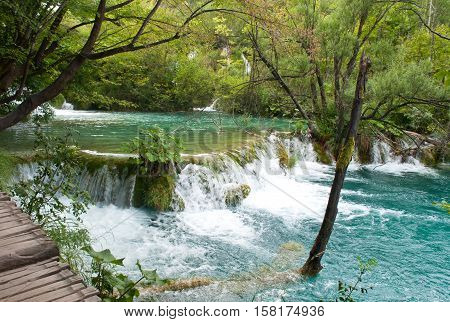Milka Trnina waterfall near a hiking path among green trees and grass in summer. Plitvice lakes national park Croatia