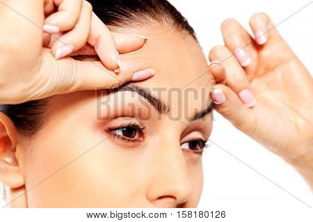 Worried young woman checking wrinkles on forehead