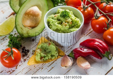 Guacamole sauce and indredients on wood background, copy space