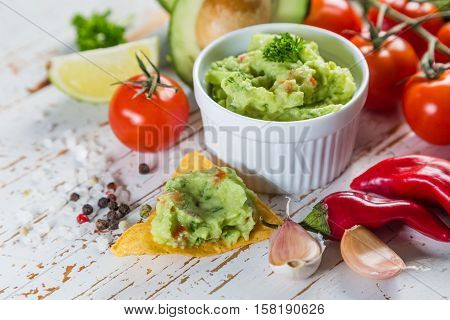 Guacamole sauce and indredients on wood background, copy space