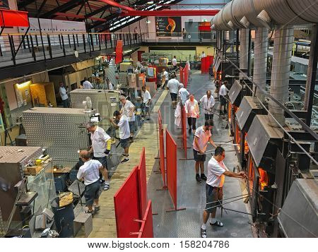 KUFSTEIN, AUSTRIA - SEPTEMBER, 2016 : Male workers working on making glass at Riedel in Kufstein, Austria on September 19, 2016. Riedel is the wine glass blowing manufacturer company