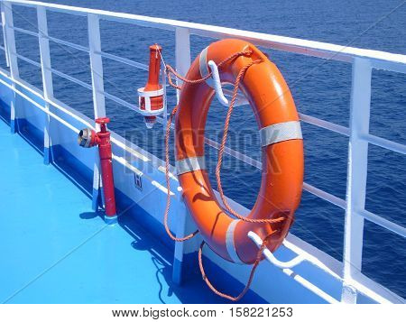 Bright orange life buoy on ferr boat in Greece