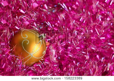 Photo by yellow christmas ball with ornament in the pink tinsel.
