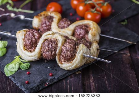 meatballs in the dough on a dark background
