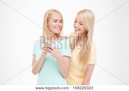 Picture of young cheerful lady showing her phone to the friend. Isolated over white background.
