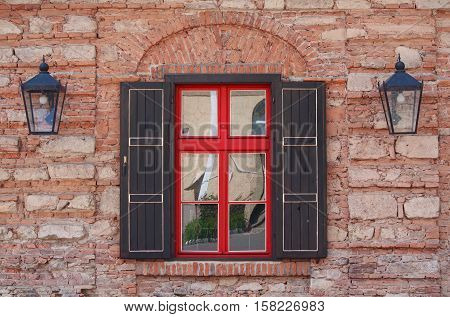 Red wooden window and brick wall. Urban