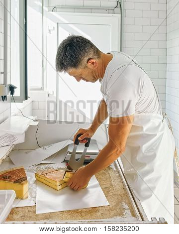 Cheese Maker Cutting Morbier Cheese At The Dairy