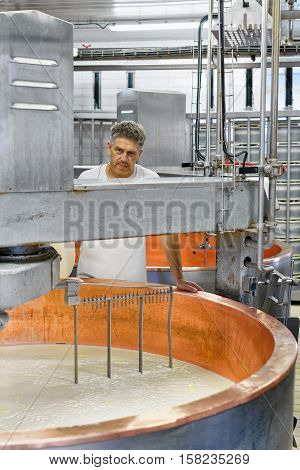 Evillers, France - August 31, 2016: Cheese maker processes Gruyere de Comte Cheese at the dairy in Franche Comte Burgundy France.