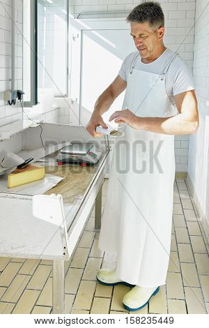Cheese Maker Wrapping Gruyere De Comte Cheese At Dairy