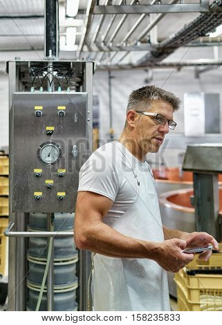 Cheesemaker Working At Gruyere Comte Cheese Dairy