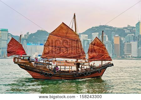 Junk Boat At Victoria Harbor In Hong Kong At Sunset