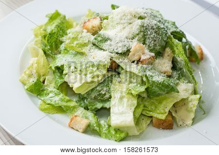 Caesar salad with cheese and croutons on plate