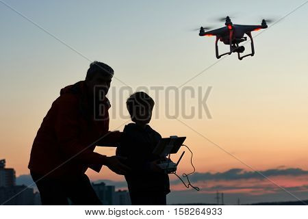 man operating of flying drone at sunset
