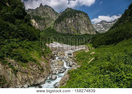 Cool mountain stream flowing from under the glacier. Highland pass in Upper Kodori District near border of Georgia - Abkhazia